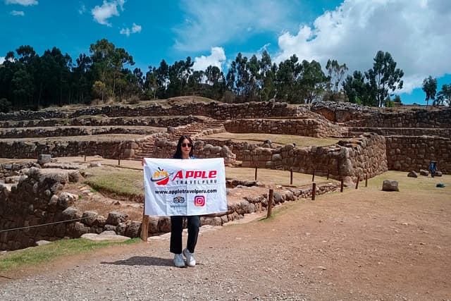 A smiling female tourist with Apple Travel Peru's flag during a city tour