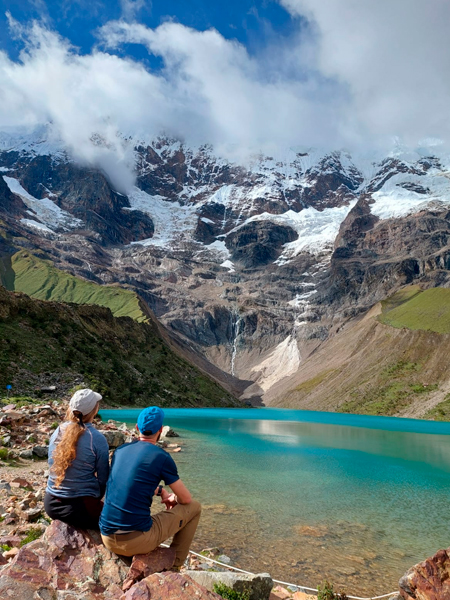 male and female tourists are sitting at Salkantay Lake